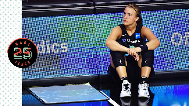 Sabrina Ionescu sitting on the court, looking pensive